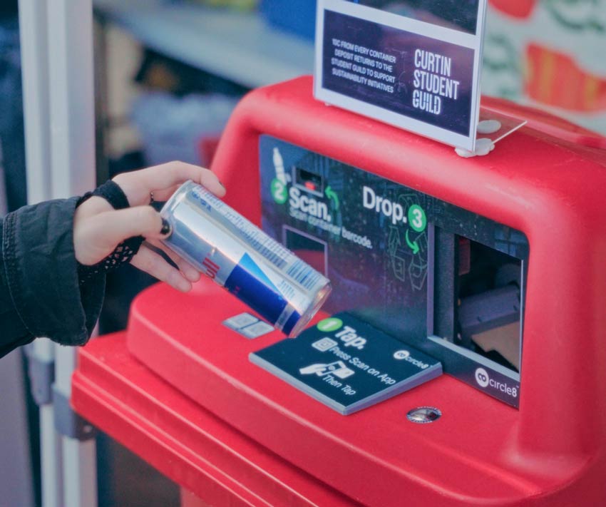 A person holding a can ready to insert into a smart bin